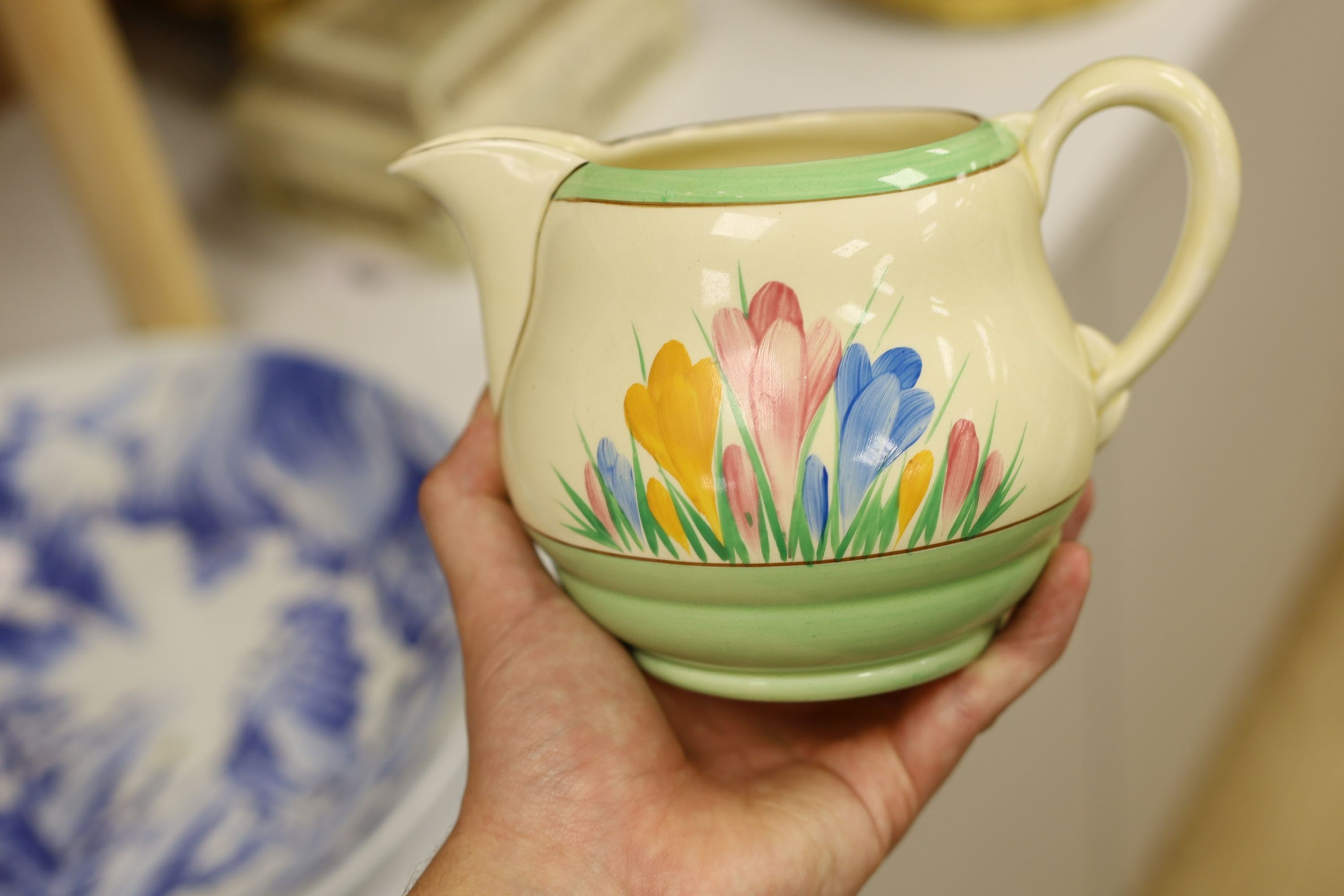 A Clarice Cliff crocus design milk jug and a Bizarre patterned side plate, jug 11.5 cms high